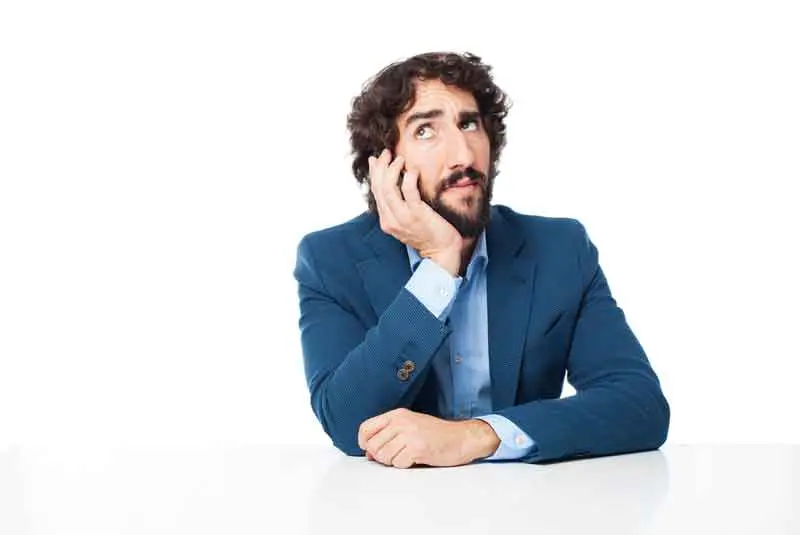 A man in a blue suit embodying branding design, sitting at a table.